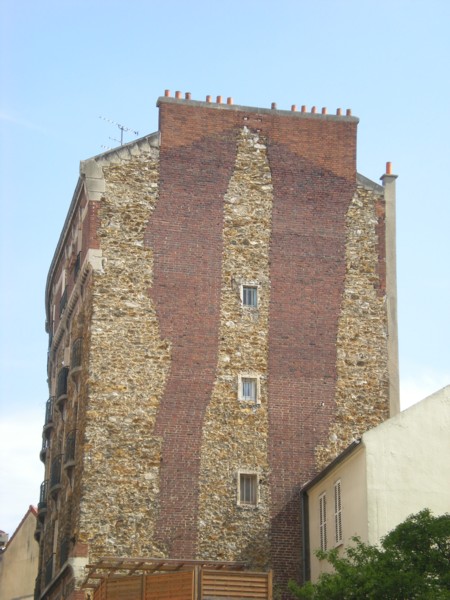 Figure 10 : Les cheminées en briques insérées dans le mur pignon en meulière.